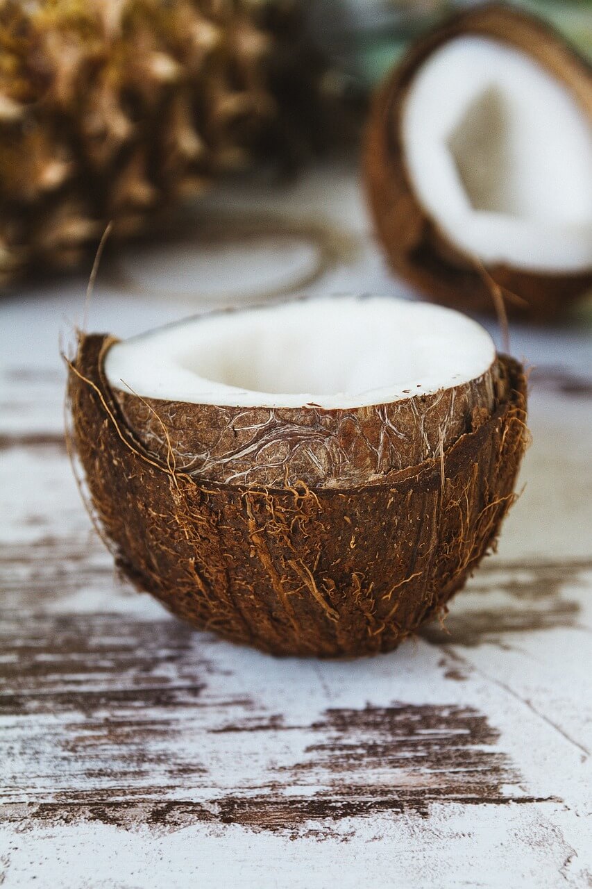 Half a coconut, resting on rustic wooden surface